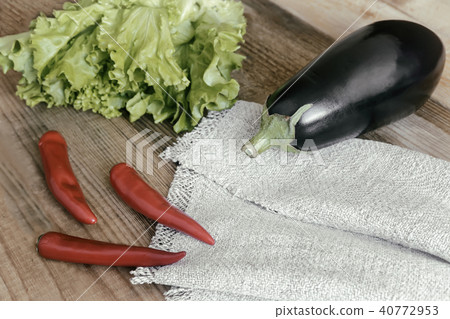 Green salad, eggplant and chili on a wooden table. 40772953