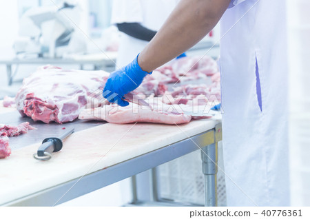 butcher cutting the fresh meat in ham factory butcher cutting the fresh meat in ham factory 40776361