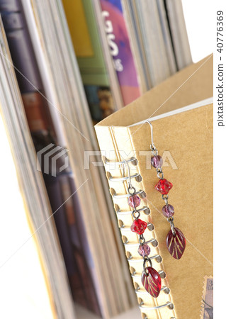 Pierced ears and books hanging in notepad Pierced ears and books hanging in notepad 40776369
