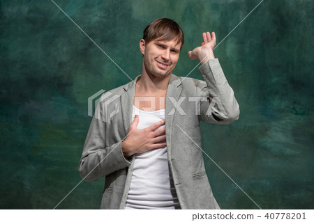 Beautiful male half-length portrait at studio backgroud. The young emotional surprised man Beautiful male half-length portrait at studio backgroud. The young emotional surprised man 40778201
