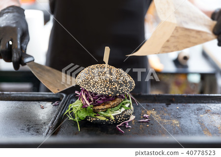Chef preparing burgers at grill plate on international urban street food festival. Chef preparing burgers at grill plate on international urban street food festival. 40778523
