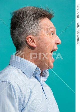 The emotional angry man screaming on blue studio background 40779040