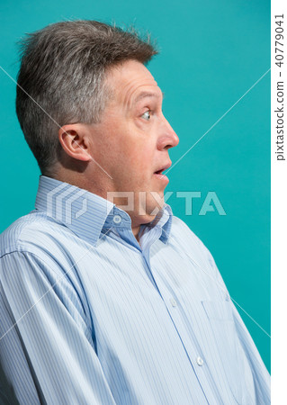 The attractive man looking suprised isolated on blue The attractive man looking suprised isolated on blue 40779041