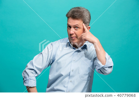 Beautiful male half-length portrait isolated on blue studio backgroud. The senior emotional Beautiful male half-length portrait isolated on blue studio backgroud. The senior emotional 40779068