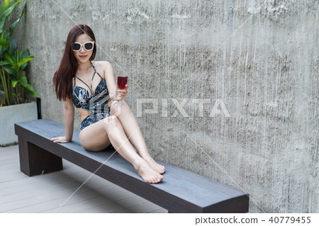 wwoman on deckchair and holding a glass in pool wwoman on deckchair and holding a glass in pool 40779455