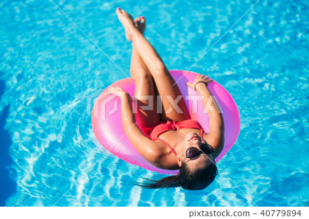 Sexy woman in bikini enjoying summer sun and tanning during holidays in pool. top view 40779894