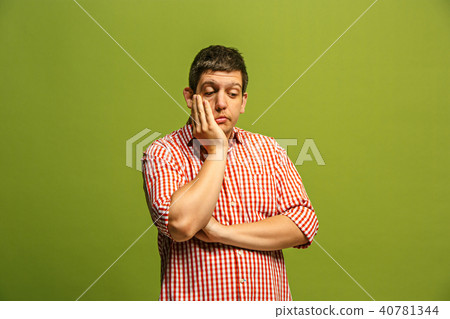 Let me think. Doubtful pensive man with thoughtful expression making choice against green background 40781344