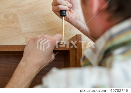 Photo of man with screwdriver picking box 40782746