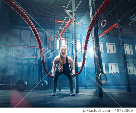 Woman with battle rope battle ropes exercise in the fitness gym. 40783869