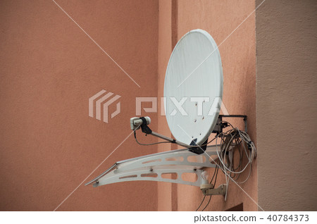 closeup of satellite antena on orange home facade closeup of satellite antena on orange home facade 40784373