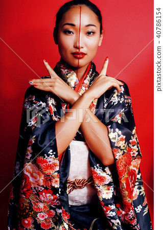young pretty geisha on red background posing in kimono, oriental young pretty geisha on red background posing in kimono, oriental 40786154