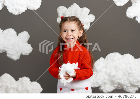 girl playing with clouds, dressed in red sweater girl playing with clouds, dressed in red sweater 40786273