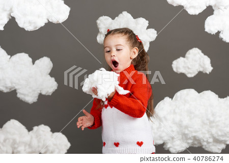 girl playing with clouds, dressed in red sweater girl playing with clouds, dressed in red sweater 40786274