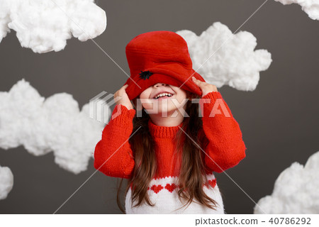 girl playing with clouds, dressed in red sweater girl playing with clouds, dressed in red sweater 40786292