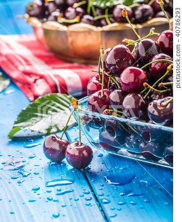 Ripe sweet cherries on blue woden table with water Ripe sweet cherries on blue woden table with water 40786293