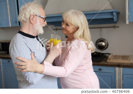 Old couple having juice in kitchen. 40786406