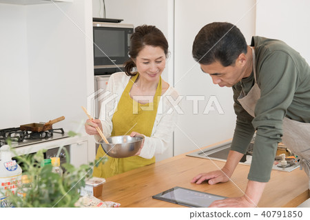 通過看食譜烹調的中間資深夫婦 通過看食譜烹調的中間資深夫婦 40791850