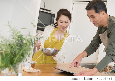 通過看食譜烹調的中間資深夫婦 通過看食譜烹調的中間資深夫婦 40791851