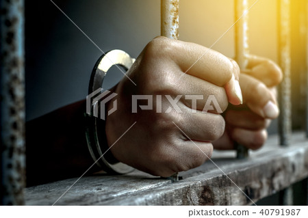 hand of prisoner holding metal prison 40791987