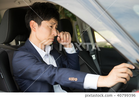 在駕駛期間沮喪的一個年輕商人 在駕駛期間沮喪的一個年輕商人 40799396