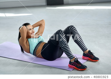Sideview of sporty woman with strong body making exercises for ABS. 40801923