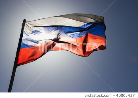 russian flag flying in slow motion and back lit by the sun. 40803437