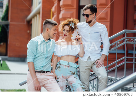 beautiful girl communicates with two stylish guys 40809763