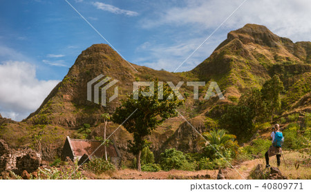 Panoramic view of woman tourist with blue backpack making photo of landscape in Mountains of Santo 40809771