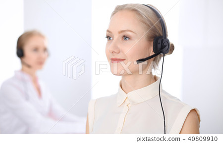 Bright  call center office. Two blonde women in a headset 40809910