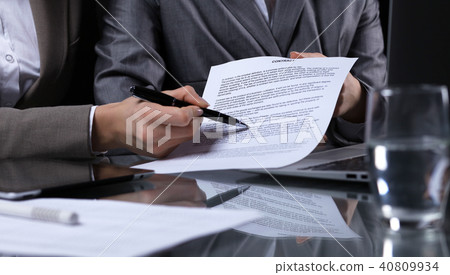 Businesspeople or lawyers signing contract at meeting. Close-up of human hands at work. Low key 40809934