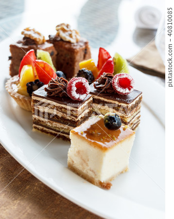 Set of mini cakes in assortment on white plate. Set of mini cakes in assortment on white plate. 40810085