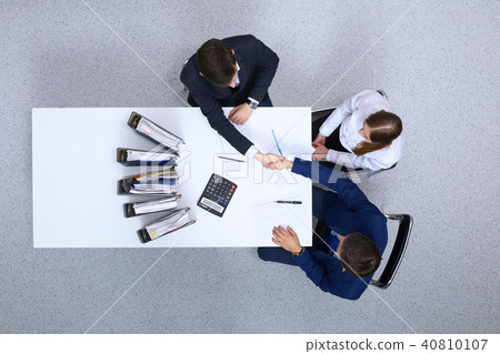 Business people shaking hands at meeting, view from above. Bookkeeper or financial inspector makin Business people shaking hands at meeting, view from above. Bookkeeper or financial inspector makin 40810107