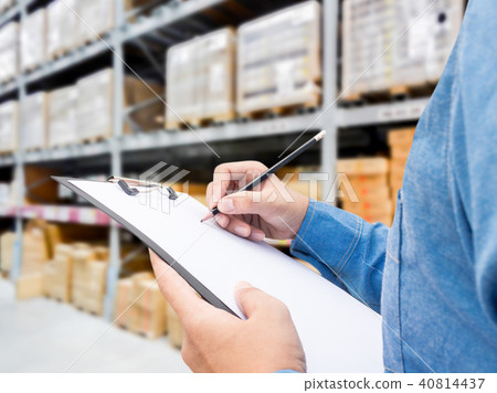 Man checking  list on clipboard in a warehouse 40814437