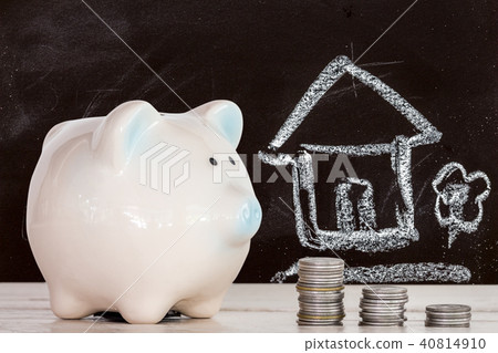 Piggy bank and coins on chalk board with home  40814910