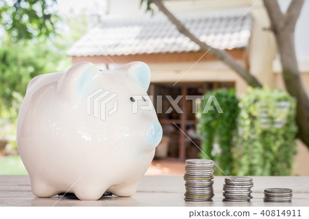 Piggy bank and coins on home blur background Piggy bank and coins on home blur background 40814911