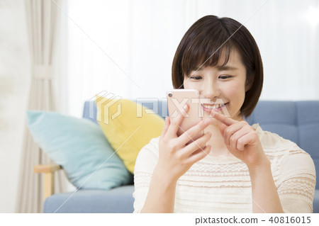 A young woman operating a smartphone A young woman operating a smartphone 40816015