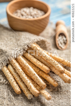 Fresh baked grissini bread on wooden board. 40822221