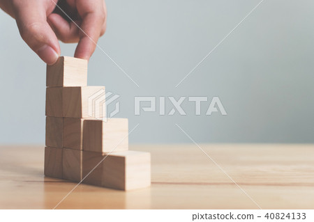 Hand arranging wood block stacking as step stair 40824133