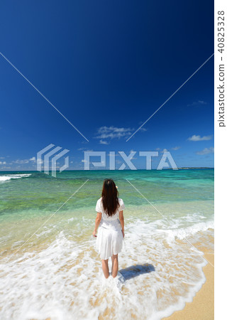 A woman relaxing on the beautiful beach of Tropical Okinawa A woman relaxing on the beautiful beach of Tropical Okinawa 40825328