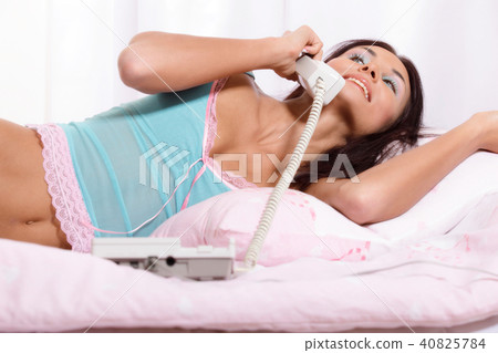 Young woman on the phone on the bed Young woman on the phone on the bed 40825784
