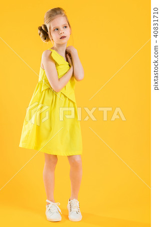 The blonde girl put her hands to her neck and looks away. 40831710