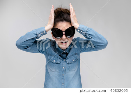 Young brunette girl in black glasses. Cat glasses. The hair is gathered in a bun. The girl took her 40832095