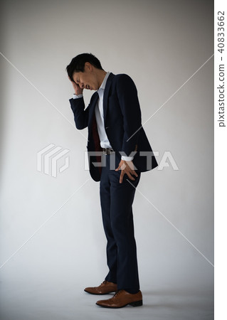 A young businessman holding a head 40833662