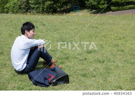 A young businessman who takes a break in the park 40834163