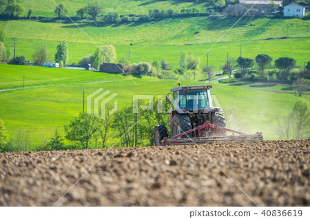 Tractor plowing field and beautiful landscape, France Tractor plowing field and beautiful landscape, France 40836619