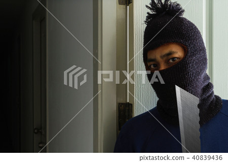 Masked robber with knife hiding behind the door Masked robber with knife hiding behind the door 40839436