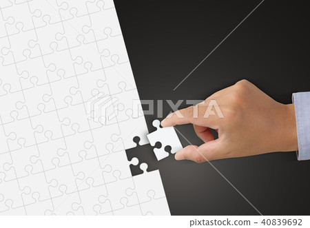 Hand holding Piece of white Jigsaw puzzle Hand holding Piece of white Jigsaw puzzle 40839692