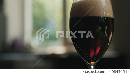 dark lager beer into a glass backlit by sunset light dark lager beer into a glass backlit by sunset light 40845464