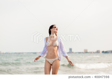 Woman in bikini walking down the beach in her summer vacation 40847398