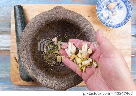 Chef put coriander,pepper and garlic to mortar 40847403